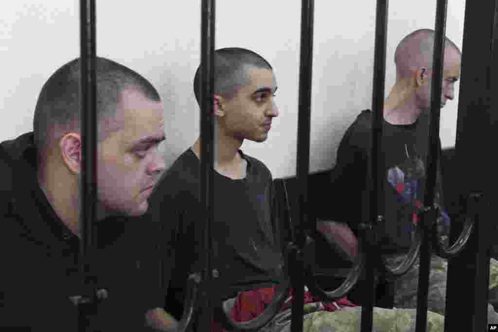 Граждане Великобритании Эйден Эслин и Шон Пиннер и марокканец Брагим Саадун во время так называемого «суда» в оккупированном Донецке 9 июня 2022 года, где группировка «ДНР» вынесла им смертные приговоры 