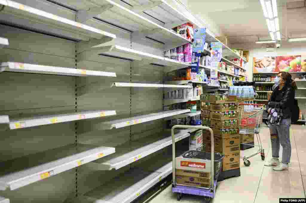 A woman looks at empty supermarket shelves in Hong Kong. 