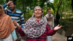 A woman reacts after her house was damaged by Pakistani artillery shelling in Uri, a village north of Srinagar in Indian-controlled Kashmir