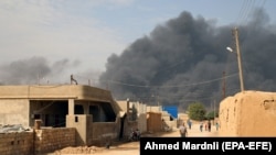 Smoke clouds rise from the scene of clashes between the Kurdish fighters and Turkish forces near the Syrian town of Ras al-Ayn on October 17.