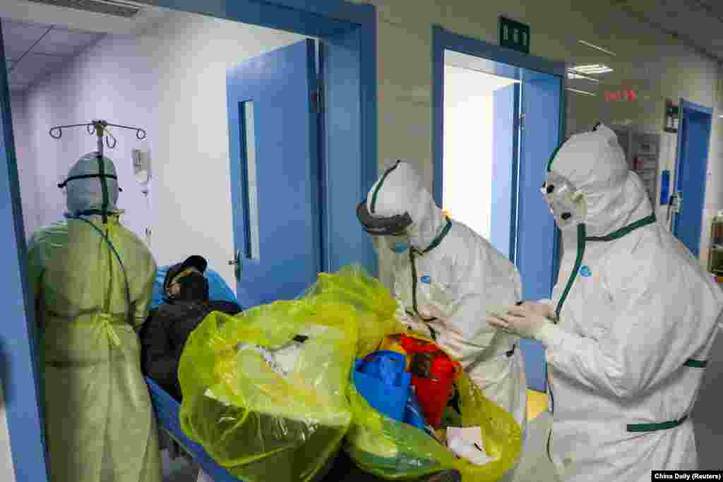 Medical workers in protective suits move a coronavirus patient in an isolation ward of a hospital in Wuhan, China.