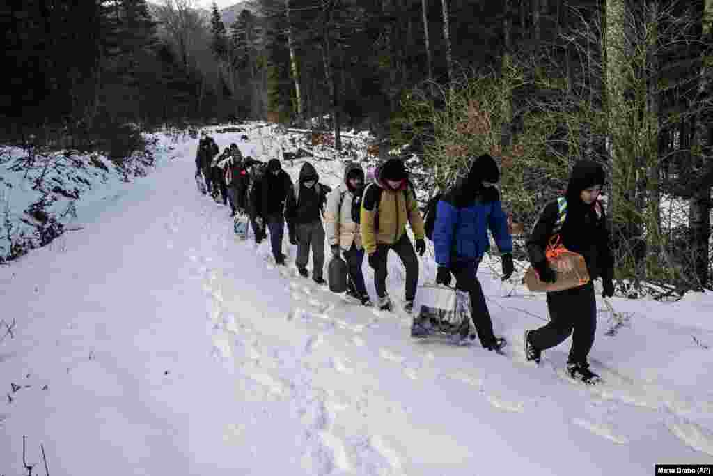 Një grup migrantësh egjiptianë ecin nëpër dëborë në një zonë malore, e cila besohet të jetë e minuar që nga koha e luftës në Bosnje. 