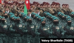 Azeri katonák menetelnek. Az azeri-örmény konfliktus több ezer áldozatot követelt; katonák és civilek is odavesztek.