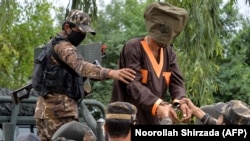 FILE: Afghan soldiers taking away alleged Islamic State (IS) fighters after they are presented to media in the eastern city of Jalalabad in May.