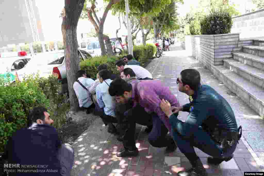 Police and civilians near parliament take cover as shots ring out. 