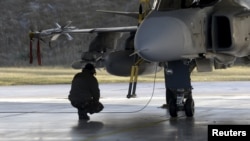 A Magyar Légierő katonája ellenőrzi a Gripen JAS–39-es vadászgépet a NATO Baltikum feletti légi rendészeti misszióján a litvániai šiauliai légi bázison 2015. december 8-án (képünk illusztráció)