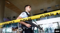 An armed Turkish policeman patrols behind a police line following the attack at Ataturk international airport in Istanbul on June 29.