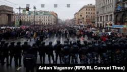 Russian law enforcement officers block a road as protesters march during a rally in support of jailed Russian opposition leader Alexei Navalny in St. Petersburg on January 23.