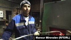 Tajik-born migrant Nazim Soliev stokes the fire at a school in Rozhdestveno, Russia