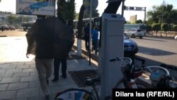 Қолшатыр ұстаған белгісіз адамның тілшіге қарсы келе жатқан сәті. Шымкент. 12 маусым, 2019 жыл.
