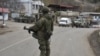 A Russian peacekeeper stands guard on a road in the town of Lachin on December 1, 2020.