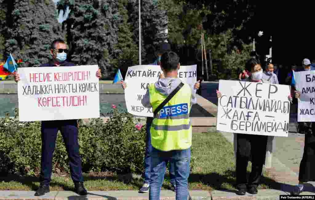 "Пресса" деген жазуы бар кеудеше киген журналист митингке қатысушыларды суретке түсіріе тұр. Алматы, 13 қыркүйек 2020 жыл.