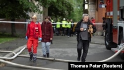 Residents leave an apartment building that was damaged in a Russian drone strike in Kyiv on May 7.