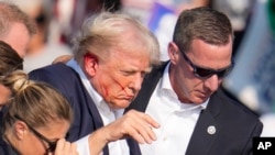 Donald Trumpot Butlerben elvezetik a kampánygyűlésről a merényletkísérlet után, 2024. július 13-án