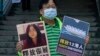 Një aktivist në Hong Kong mban në dorë fotografinë e gazetares së burgosur, Zhang Zhan, 28 dhjetor, 2020.