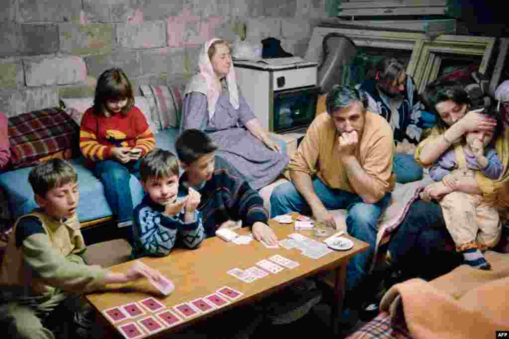 6 июня 1992 года. Семья нашла убежище в подвале, когда Сараево, столица Боснии, оказалась под обстрелами. Бои продолжались, несмотря на достигнутую при посредничестве ООН договоренность об открытии аэропорта и отводе сербских войск из казарм в центре города. 