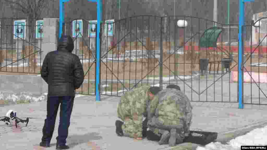 Бурыл ауылындағы жағдайды әуеден бақылау үшін дрон құралын ұшыруға дайындап жатқан әскери адамдар. 
