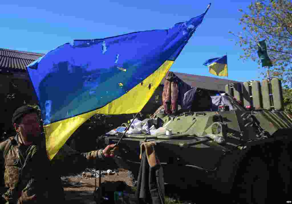 Український вояк демонструє бойовий прапор посічений кулями, військовий табір поблизу Дебальцево, 4 жовтня 2014 року