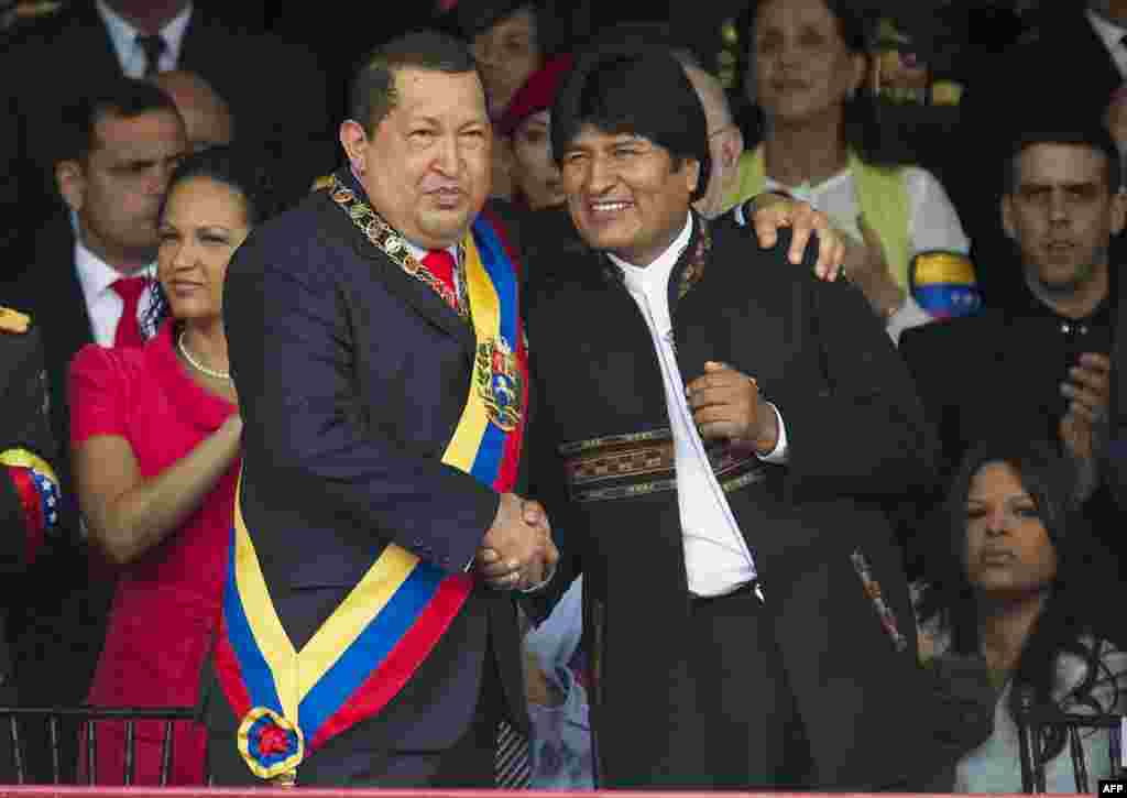 Chavez greets his Bolivian counterpart, Evo Morales (right), during a military parade to commemorate the 20th anniversary of his failed coup attempt on February 4, 2012.