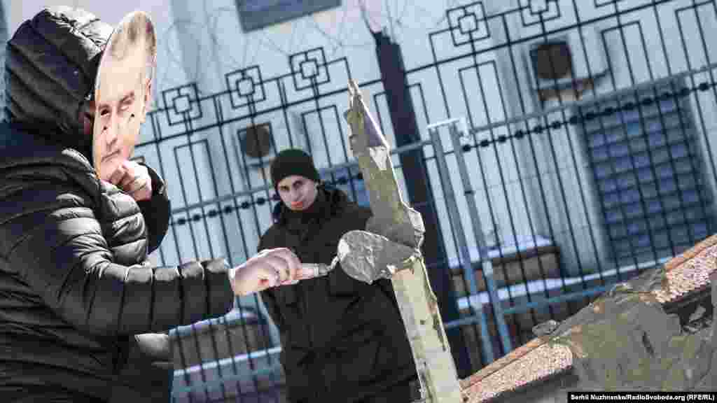 Активисты в масках президента России Владимира Путина и главы подконтрольного Кремлю правительства Крыма Сергея Аксенова «штукатурили» макет Ханского дворца