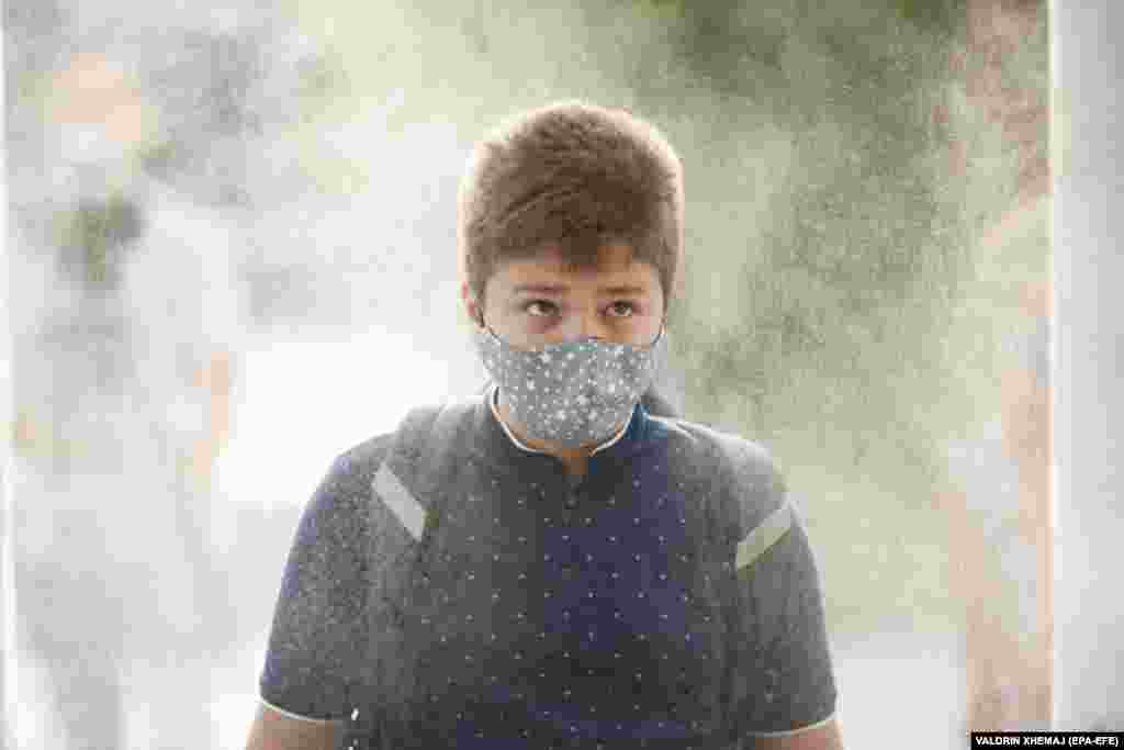 An elementary-school student wearing a face mask passes through a disinfection tunnel on the first day of school in Pristina. Kosovo's government postponed the start of the school year for two weeks due to the COVID-19 pandemic. 