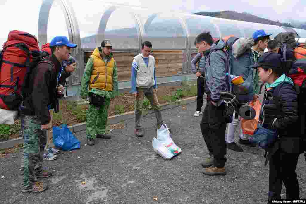 Участники экспедиции Beken Ata Expeditions: Sacred QyzEmshek собрались в нижней точке курорта «Ак-Булак» (в горах южнее города Талгар), приехав туда из Алматы на комфортабельном автобусе. Большинство участников – студенты Казахской академии туризма и спорта. С ними два преподавателя. Было несколько волонтеров. Экспедицию возглавили руководитель Фонда «Бекен Ата» Бекбол Нурмуханбетов (на фото в желтой жилетке), сын археолога Бекмуханбета Нурмуханбетова, и заместитель директора Государственного историко-культурного заповедника-музея «Иссык» Ермек Джасыбаев (справа от Бекбола). В пакете на земле – раздаточный материал для участников экспедиции.
