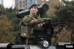 Egy Törökországban gyártott gépfegyverrel és egy belarusz tankelhárító-rakétával felszerelt jármű halad a sorban. A felvonuláson bemutattákt azoknak a fegyvereknek a nagy részét, melyeket Azerbajdzsán a közelmúltban vásárolt.