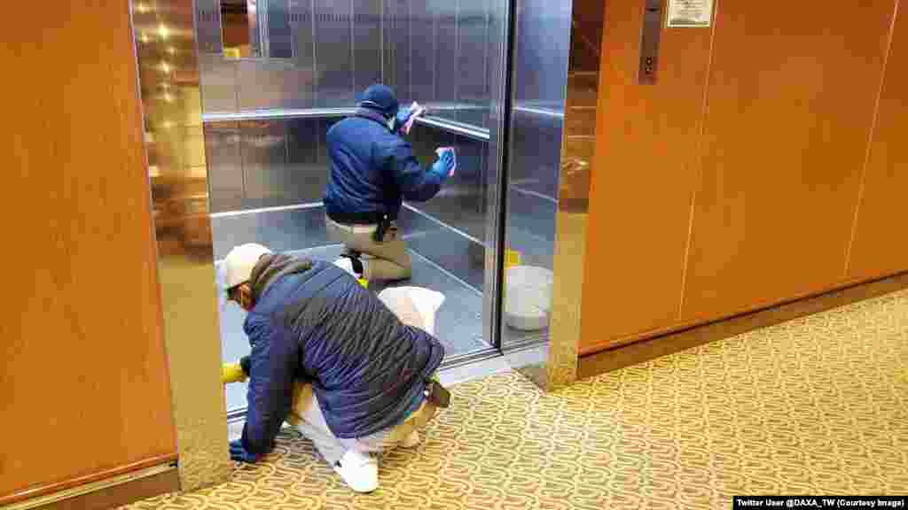 Workers disinfect an elevator inside the Diamond Princess. A crew member aboard the vessel told RFE/RL: "Horror. I can't believe this is going on aboard my ship." Infections on the ship continue to rise. 