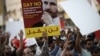 Bahraini protesters hold a placard portraying Sheikh Ali Salman, head of the Shiite opposition movement Al-Wefaq, during a demonstration against his arrest on June 16, 2015, in the village of Jidd Hafs, west of Manama.