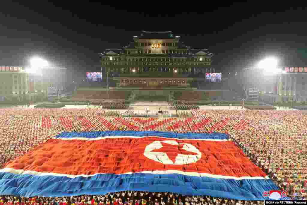 Hatalmas észak-koreai zászlót terítettek résztvevőkre. 2020-ban Kim Dzsongun már arra buzdította az embereket a Koreai Munkáspárt egyik jubileumi rendezvényén, hogy „maradjanak szilárdak a járvány által okozott óriási kihívásokkal szemben”. Az egyik ilyen kihívásnak nevezte az éhínség lehetőségét, amelyben jelentések szerint több millióan haltak meg a kilencvenes években