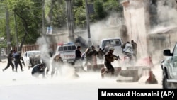 FILE: Security forces run from the site of a suicide attack in Kabul in April 2018.