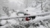 Vehicles stuck under fallen trees are seen on a snowy road, in Murree, Pakistan, on January 8.