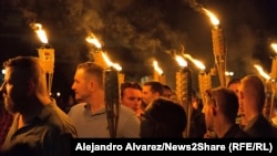 Supremacistët e bardhë gjatë një marshi me flakadanë në Sharlotsvill të SHBA-së më 11 gusht 2017. Në këtë marsh ishte i pranishëm edhe asistenti politik në Ambasadën hungareze në SHA, Taylor Ragg. 