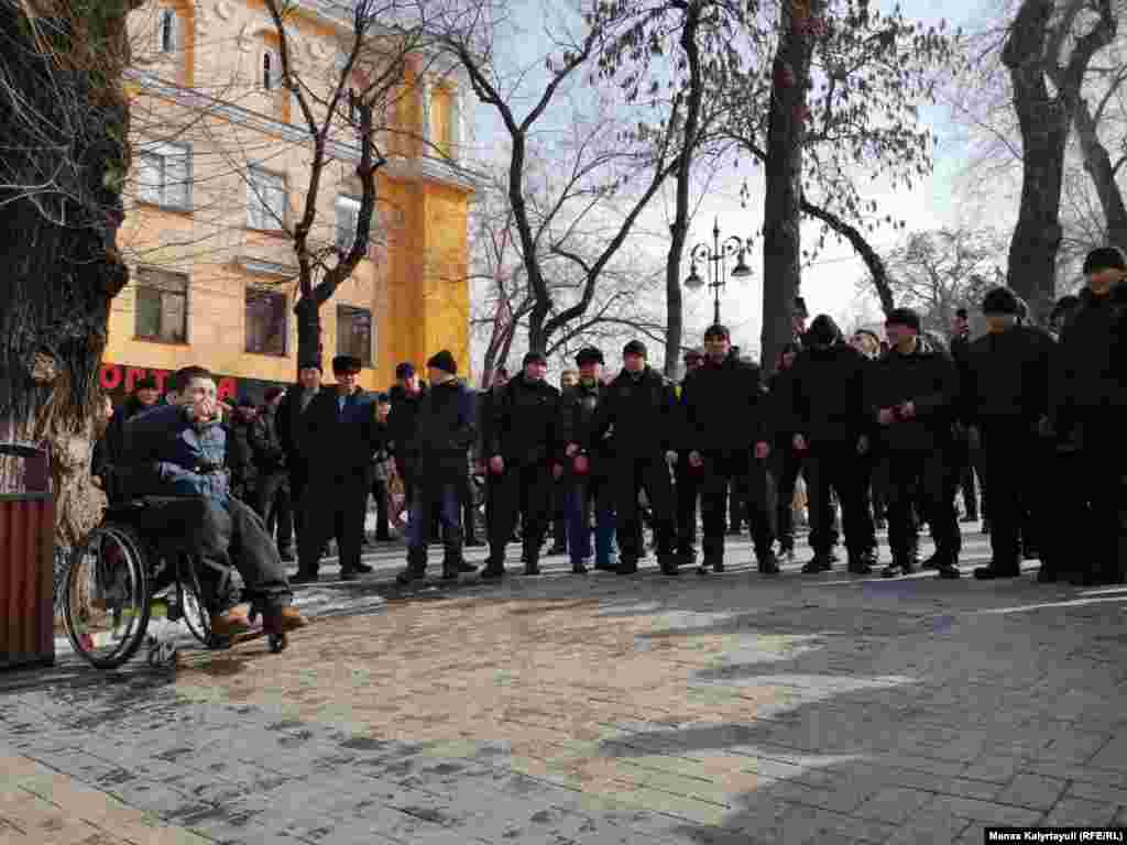 Алматыда митинг белгіленген жерге келген адамдардың бірі билікке талабын айтып тұр. Қалада сенбі күні күзет күшейді. 