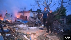 Banorët shikojnë dëmet në shtëpitë e tyre të goditura gjatë sulmeve ruse me dronë në Harkiv, Ukrainë, 21 maj 2024.