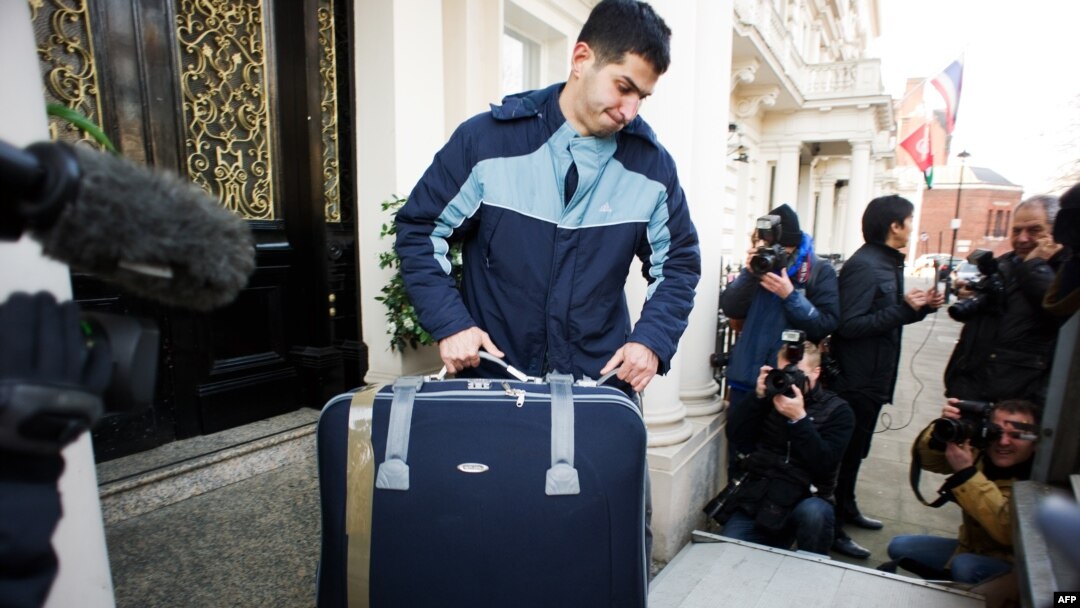 A removals worker carries a suitcase out of a residential annex of the Iranian Embassy in central London on December 2.