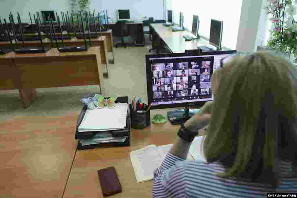 Мұғалім оқушылармен видеоконференция өткізіп, сабақты түсіндіріп жатыр. Новосибирск, Ресей. 