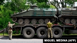 Украинские солдаты разгружают два британских бронетранспортера FV103 Spartan на востоке Украины на фоне российского вторжения в Украину. 9 июля 2022 года