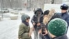 Активистка Акторгын Аккенжебаласы разговаривает с представителям власти, который прерывает ее пикет в Алматы. 22 января 2025 года