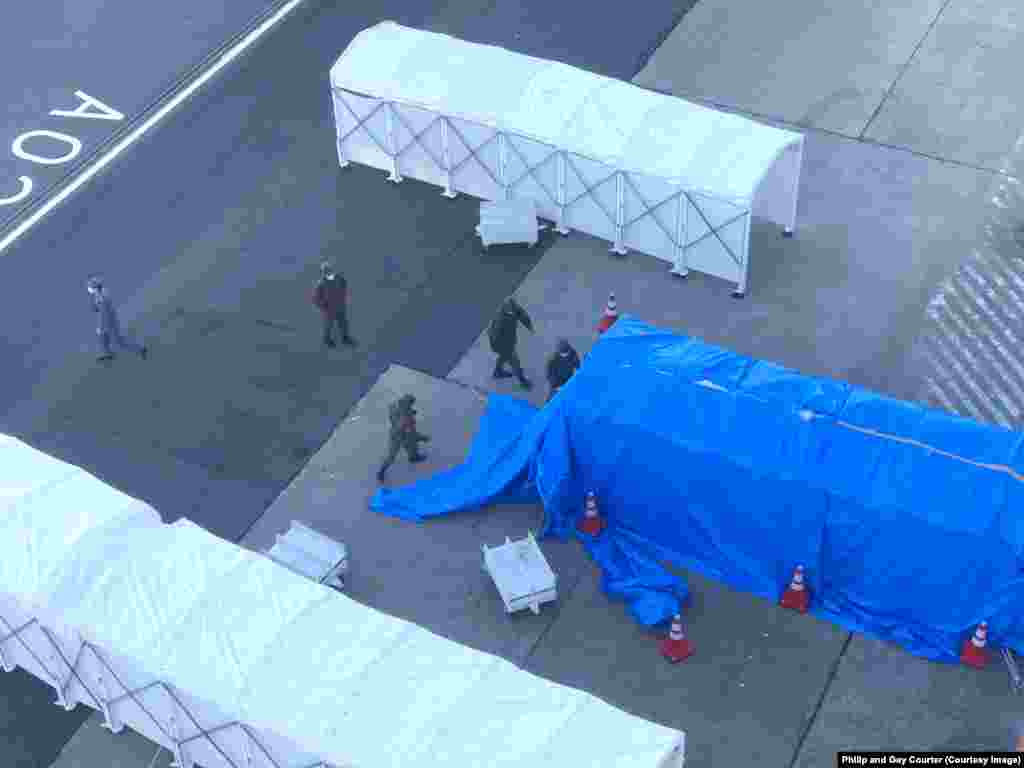 A gangplank being covered by a tarpaulin before dozens of infected passengers were evacuated from the vessel on February 10. While passengers still quarantined aboard the ship are kept informed and have been offered compensation, a crew member told RFE/RL that very little information had been given to the crew. Staff have not been told the names of infected colleagues removed from the vessel and isolated for medical treatment.
