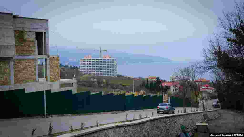 Vinogradnaya soqağında şahsiy evlerniñ qurucılığı. Yeşil qoranıñ arqasında – «Livadiya»nıñ bağları