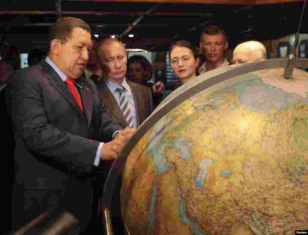 Chavez and Russian Prime Minister Vladimir Putin look at a globe while visiting the Russian Navy's "Kruzenshtern" sailing ship in the port of Guaira, near Caracas, in April 2010.