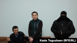 Гражданский активист Асет Абишев (в центре), принудительно доставленный из следственной тюрьмы в Алмалинский районный суд для присутствия на оглашении приговора. Алматы, 30 ноября 2018 года.