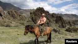 Владимир Путин, в бытность премьер-министром России, верхом на лошади в Сибири. Август 2012 года.