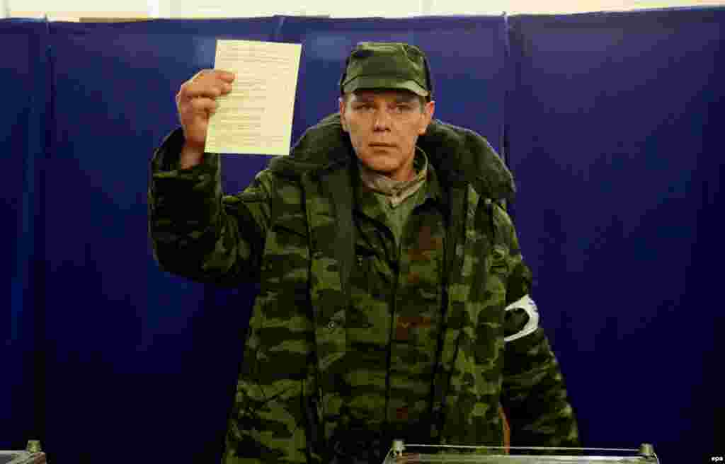 Член одного из про-российских "отрядов самообороны Крыма" показывает журналистам свою бюллетень с отметкой в графе "За вхождение в состав России"