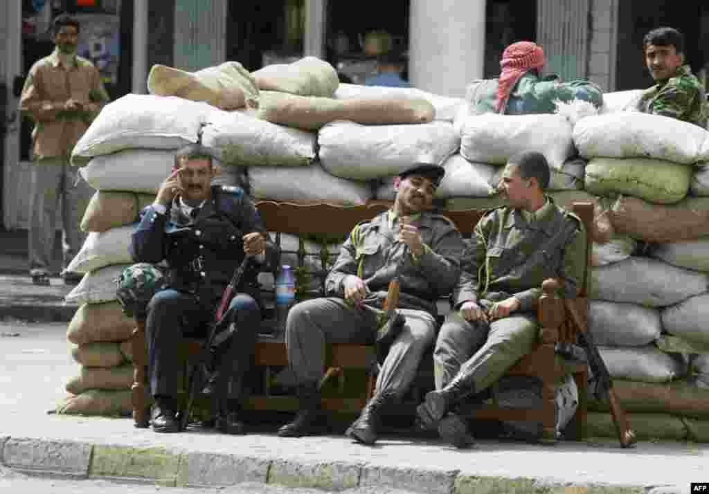 Iraqi militiamen from the ruling Ba'ath party rest in Baghdad amid the U.S. strikes on March 20.