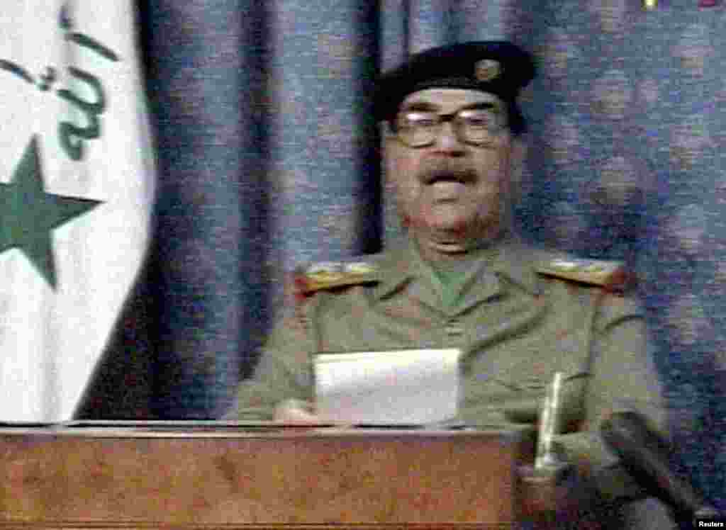 Iraqi President Saddam Hussein appears on state television just hours after the United States launched its invasion to overthrow him. In his speech, Saddam said, "The criminal little Bush has committed a crime against humanity."