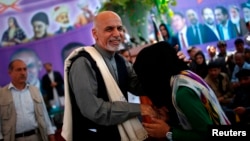 Afghan presidential candidate Ashraf Ghani Ahmadzai greets a girl at a campaign appearance in Jozjan Province on June 2.