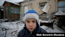 Мальчик на фоне разрушенного в результате обстрелов дома. Авдеевка, 2 февраля 2017 года