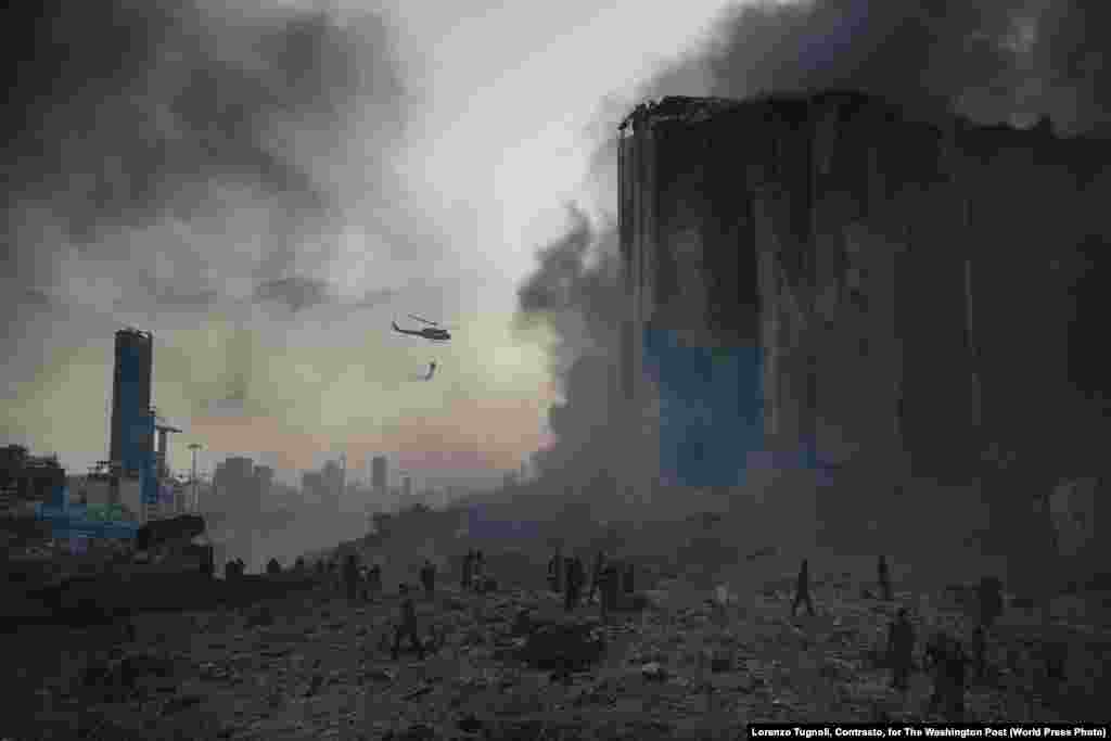 Снимок из фоторепортаж «Взрыв в порту Бейрута». На месте катастрофы работают пожарные (4 августа 2020). Около десяти пожарных погибли на месте взрыва. Первое место в категории «Срочные новости, фоторепортаж», автор – Лоренсо Тугноли